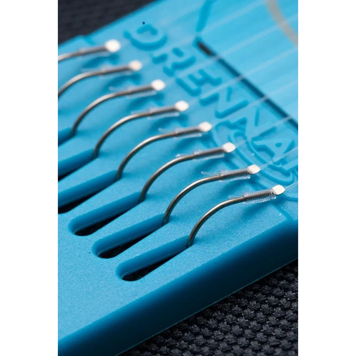 Drennan Wide Gape Pellet Barbless Hooklengths – acht weerhaakloze onderlijnen op een blauwe Hook Plate