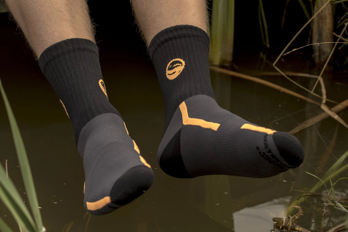 Guru Waterproof Socks, zwarte en grijze sokken met gele accenten gedragen boven het water