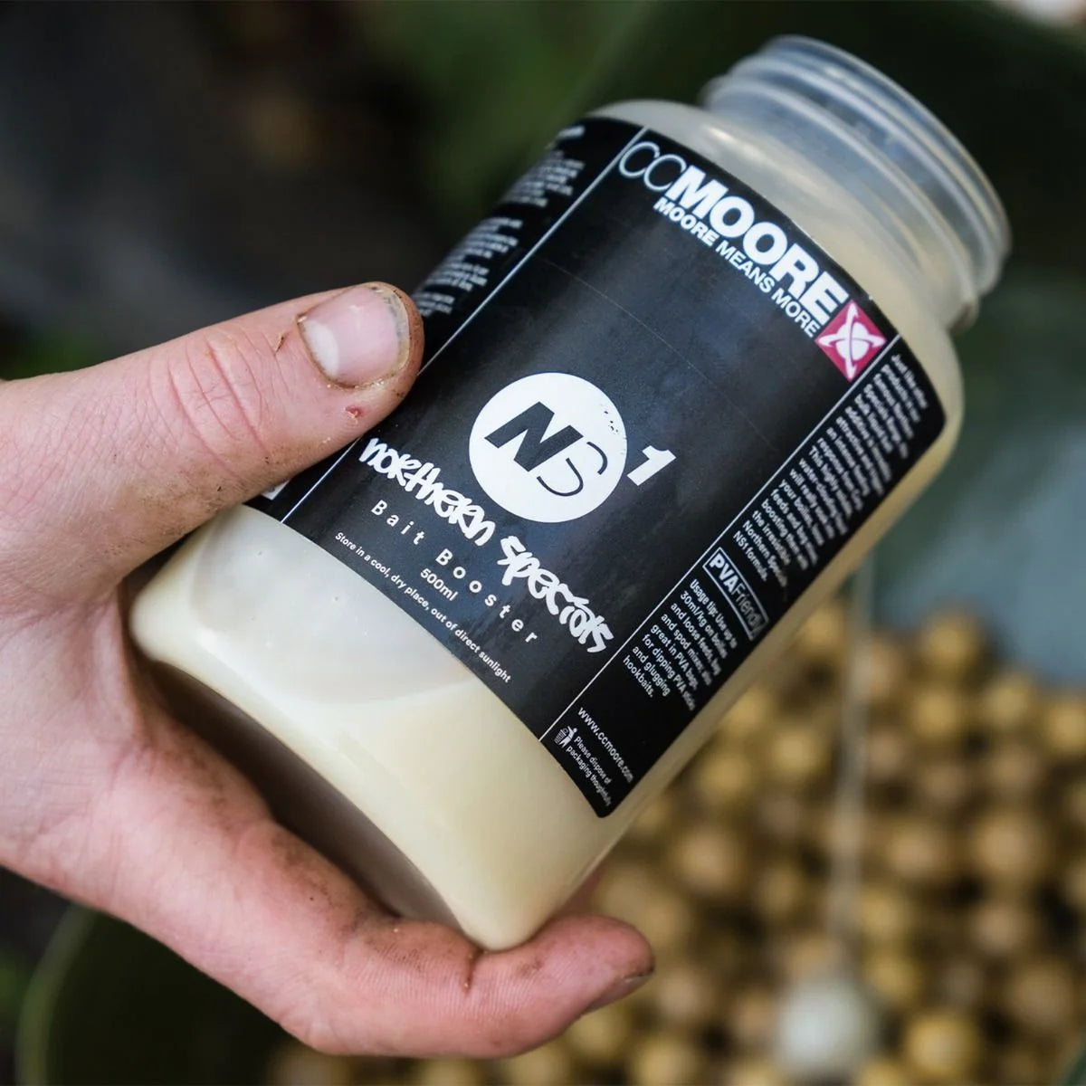 CCMoore NS1 Bait Booster 500 ml fles in een hand