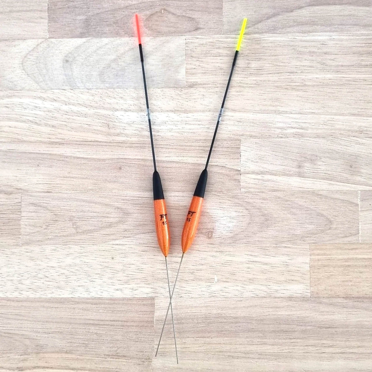 Fishing Things FT65-dobbers op hout, met rode en gele antenne en de volledige gekruiste onderstelen