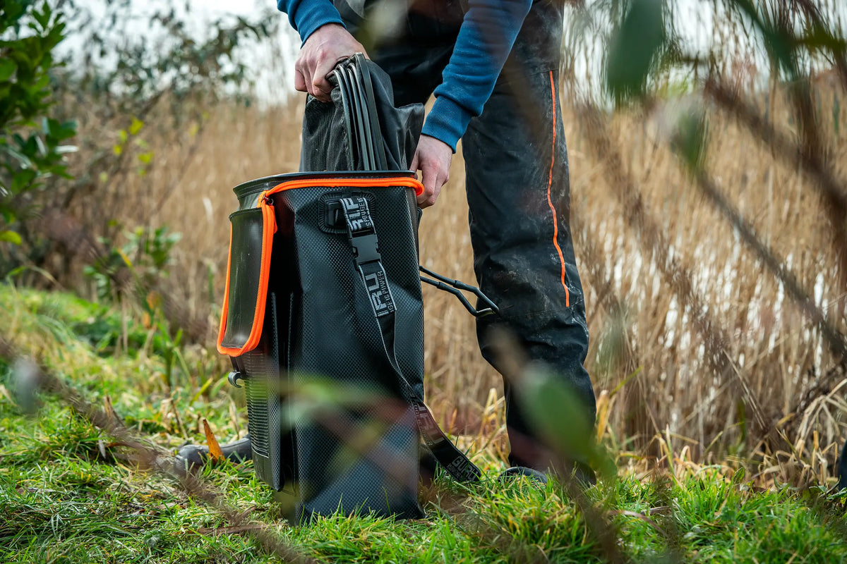 Guru Fusion Net Bag MKII – een visser bergt netten op in de tas aan de waterkant
