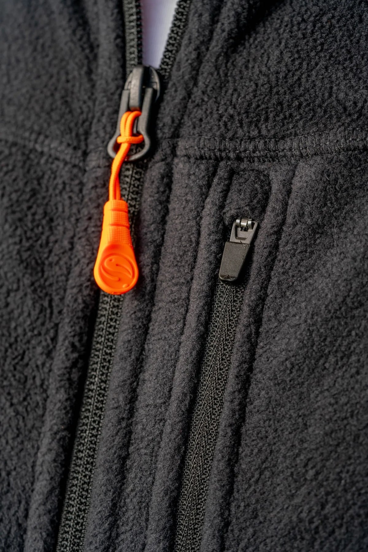 Guru Fleece Gilet Black - detail van oranje ritstrekker en borstzakrits
