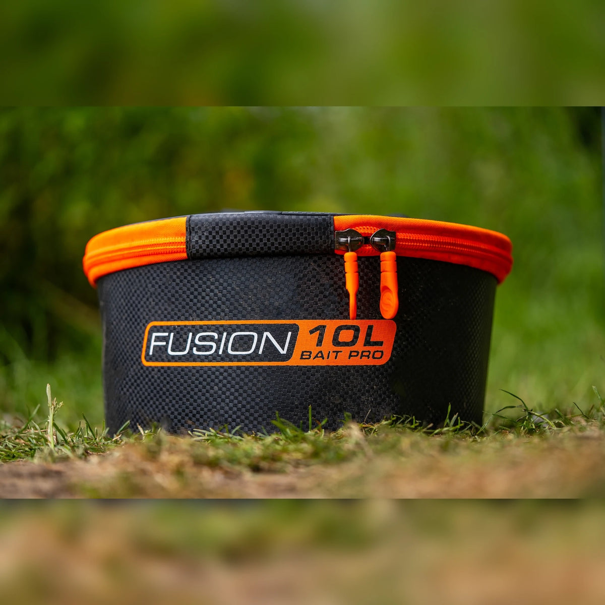 Guru Fusion Bucket10L – Fusion10L emmer met oranje ritsrand op de grond aan de waterkant