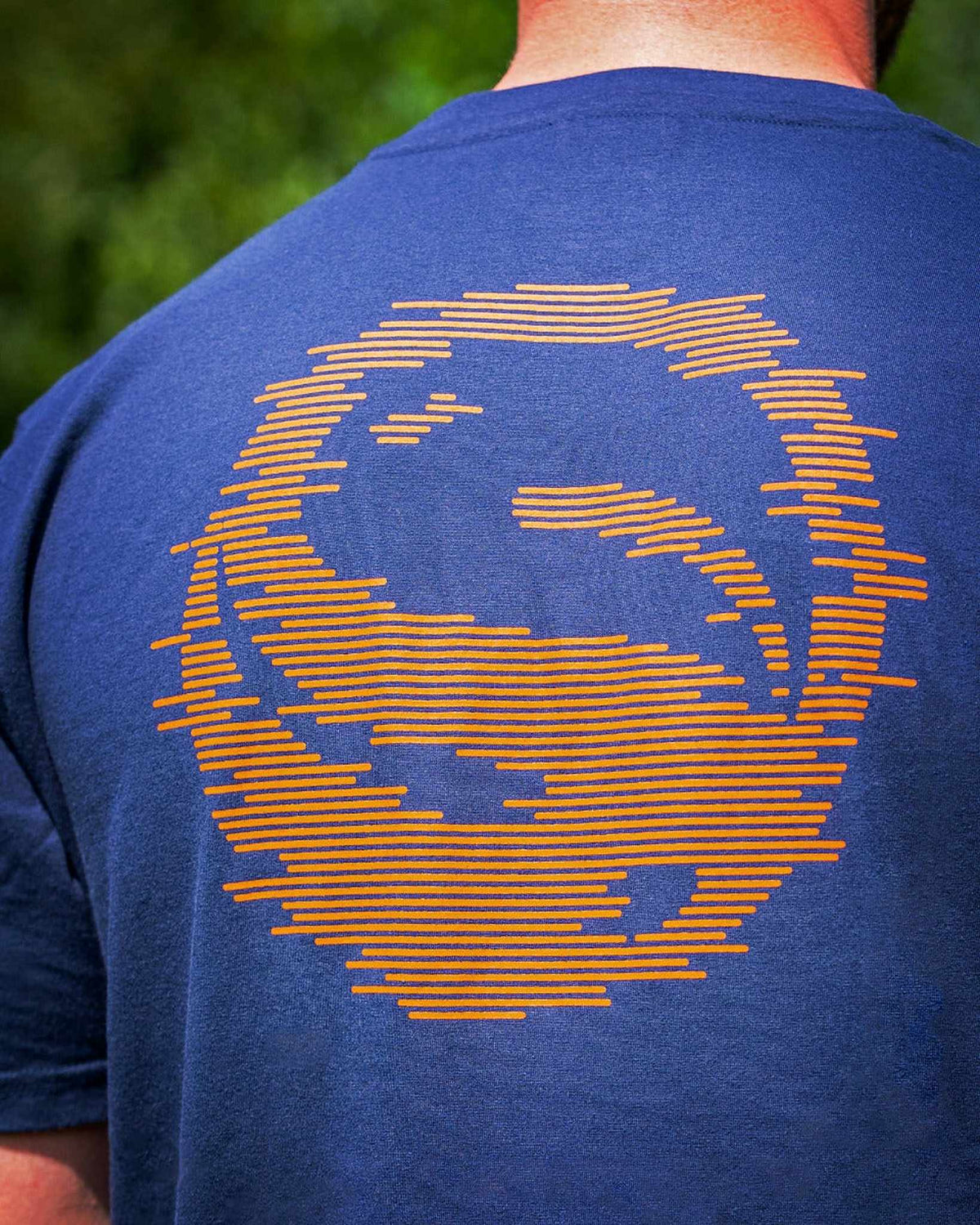 Guru Glitch Navy Tee – close-up van de grote oranje Glitch-rugprint op de marineblauwe stof
