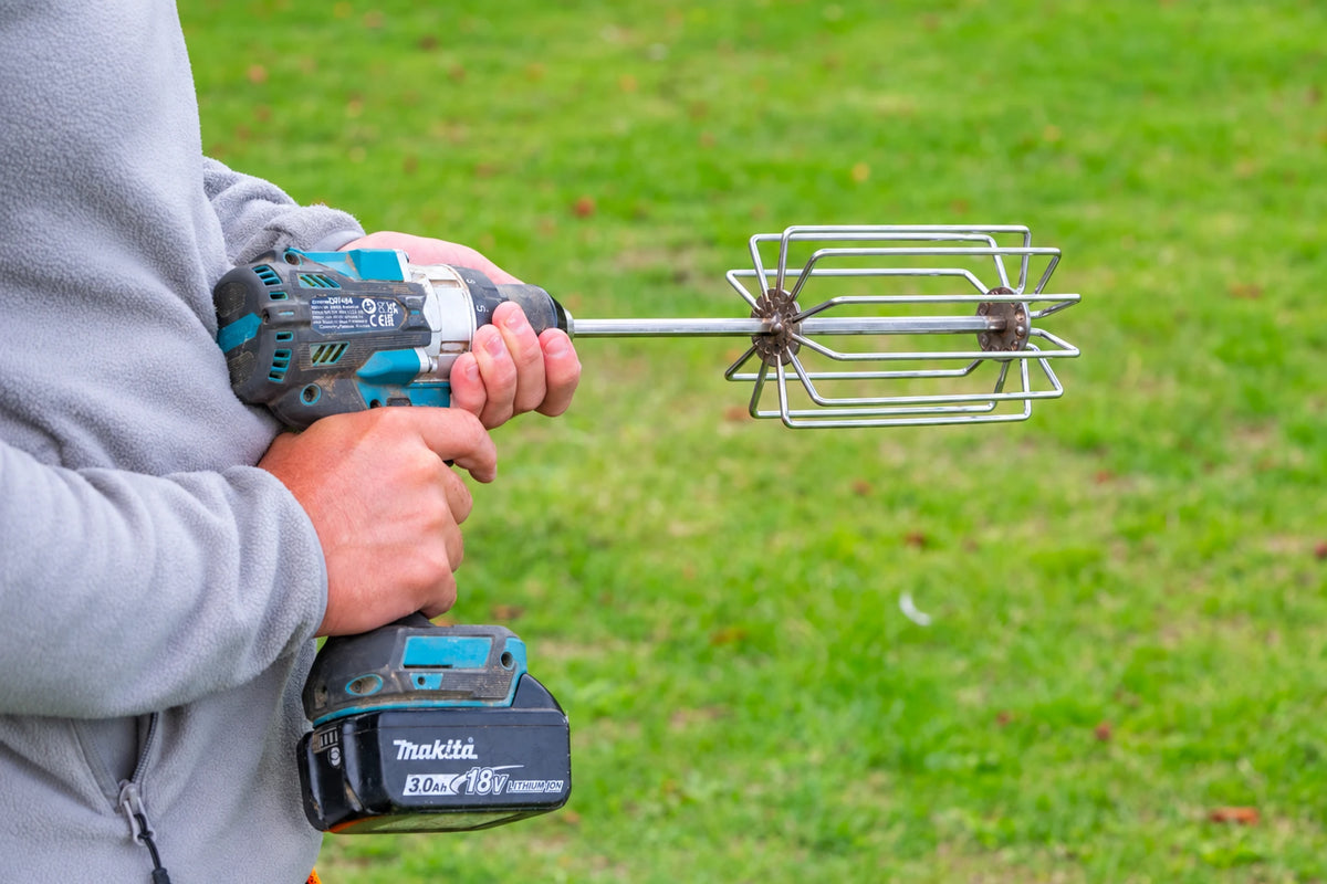 Guru Ground Bait Whisk gemonteerd op een boormachine, klaar om grondvoer te mengen