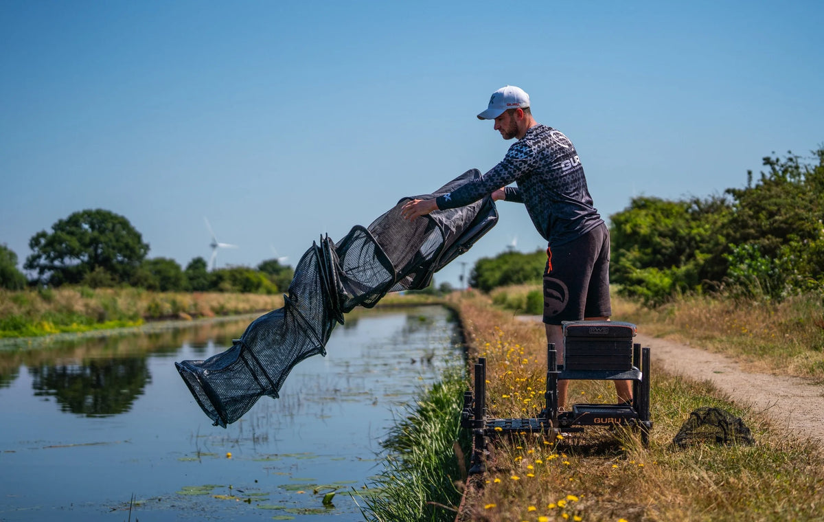 Guru Carp Match 3m leefnet – visser strekt het leefnet uit aan de waterkant