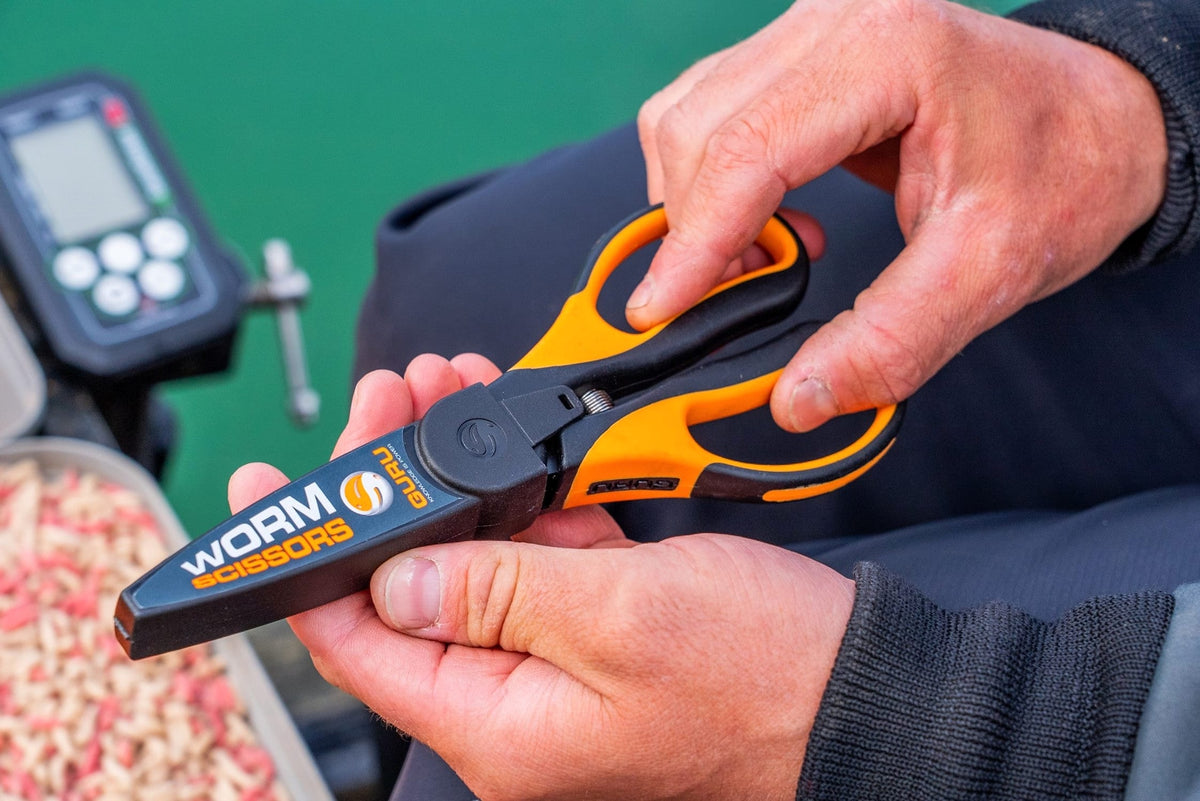 Guru Worm Scissors met beschermhoes in de handen van een visser