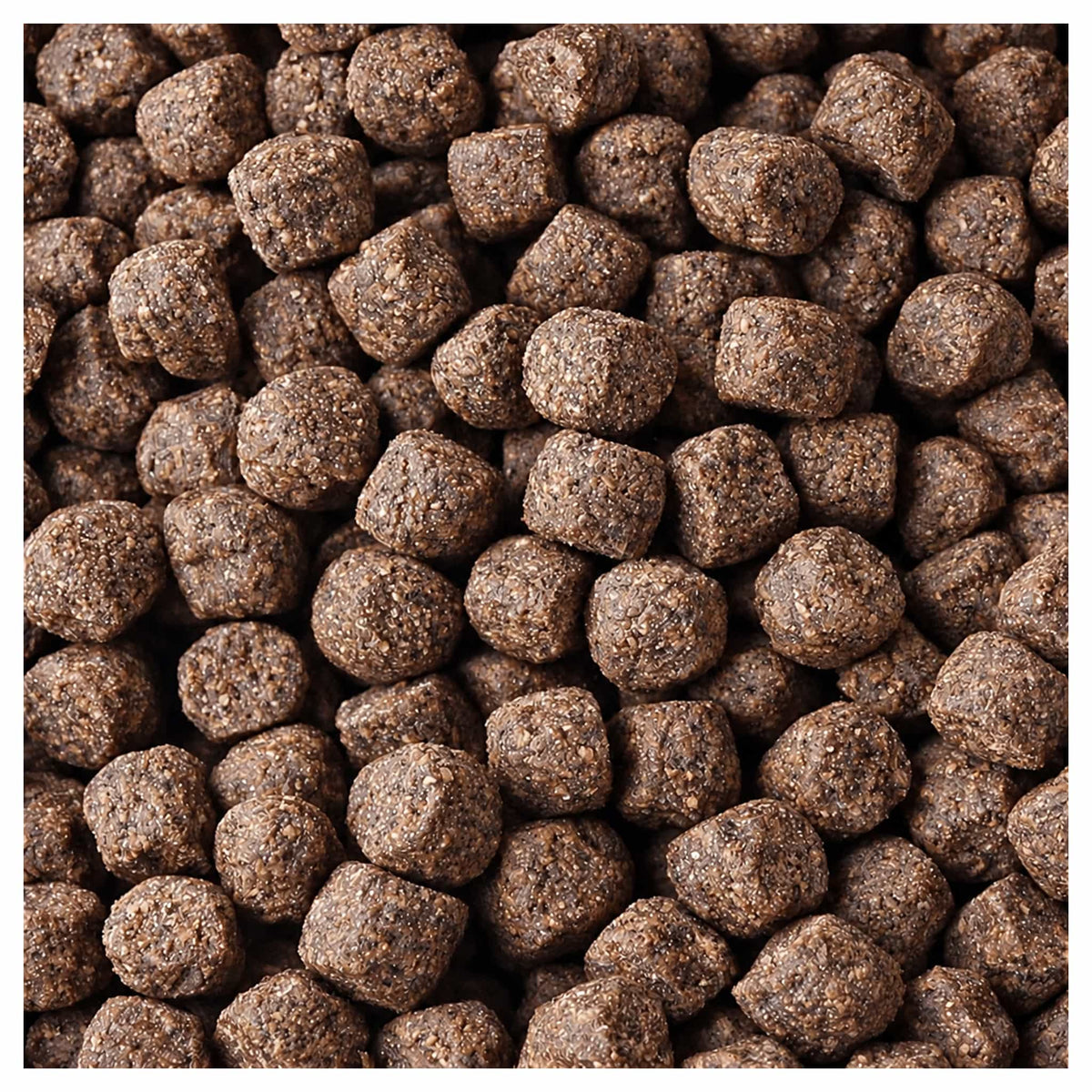 Close-up van korte bruine karperpellets met grove korrelstructuur