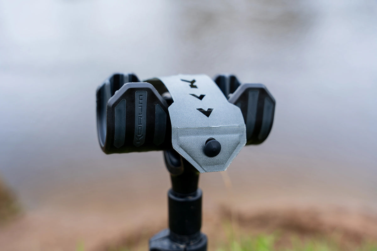 Korum Adjustable Net Saver vooraanzicht op een bankstick met gesloten grijze sluitband en Korum-logo