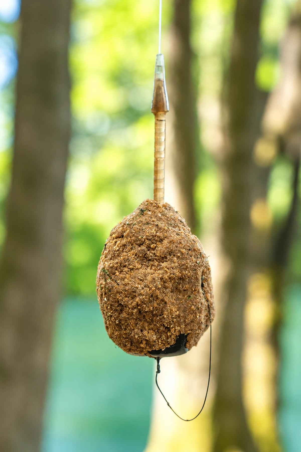 Korum Arrowhead Distance Method Feeder hangend aan de lijn, gevuld met grondvoer en met een onderlijnlus