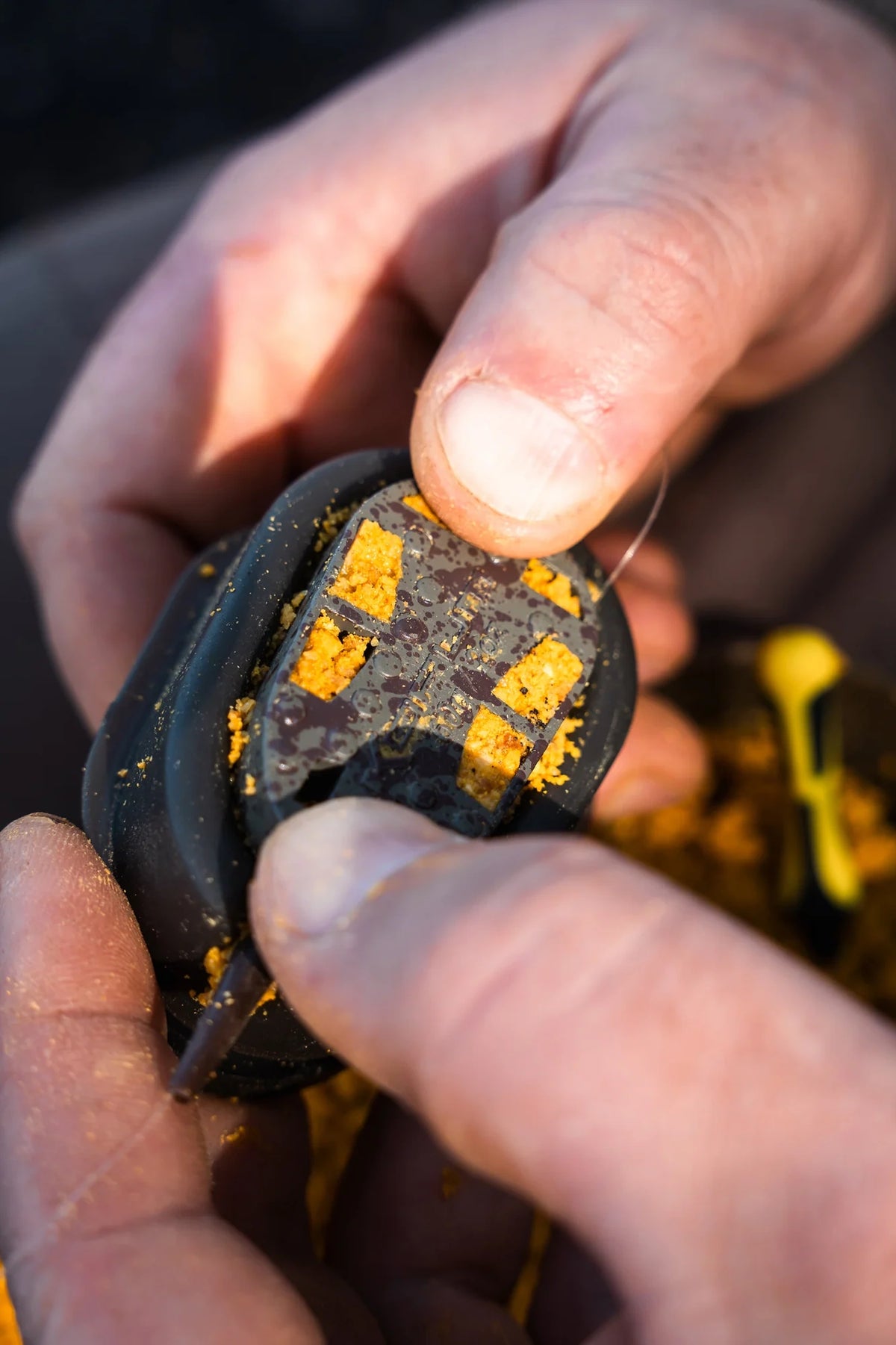Korum Lead Free Dura Method 30g – feeder wordt in de met voer gevulde mould gedrukt