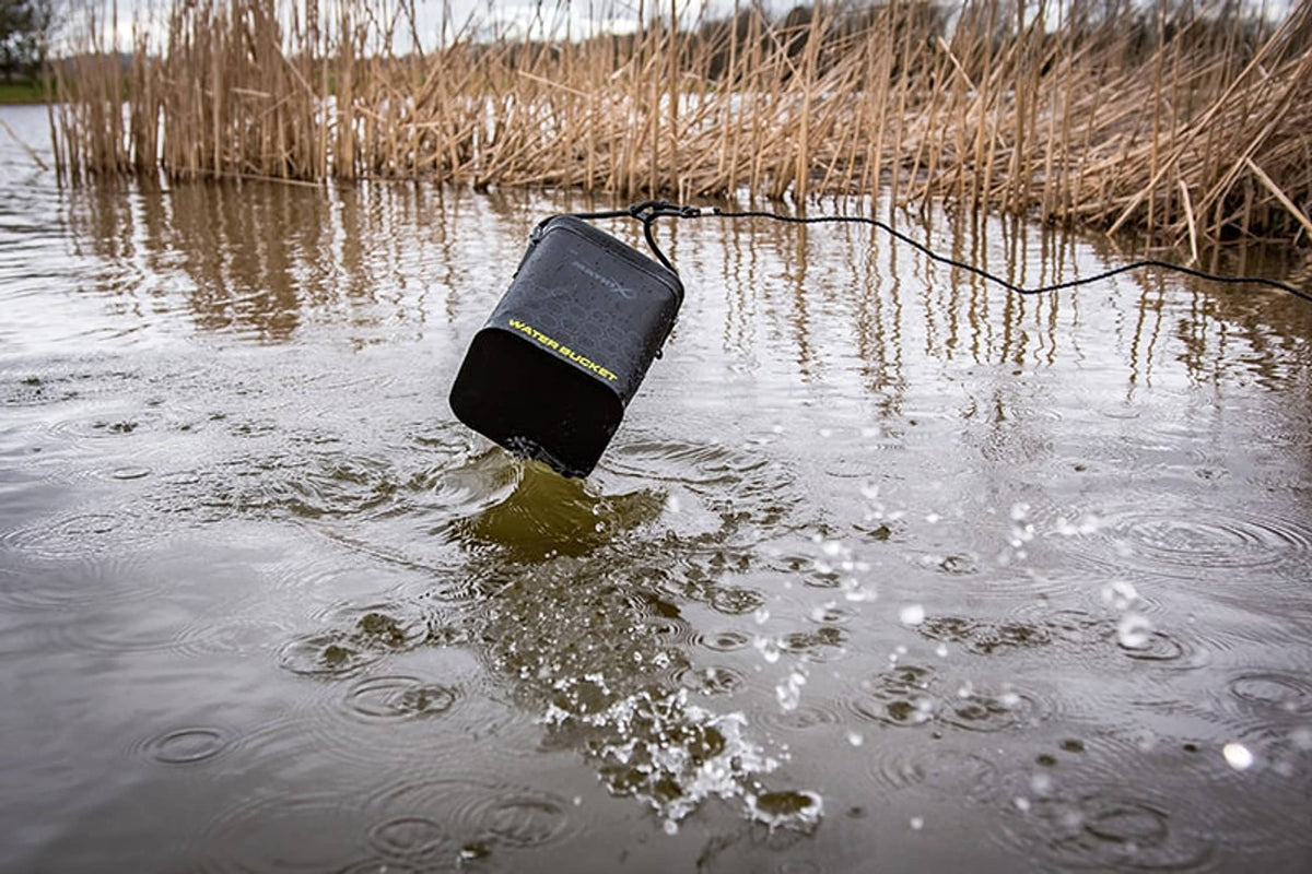 Matrix EVA Water Bucket wordt aan het koord uit het water opgehaald, met zichtbaar opspattend water