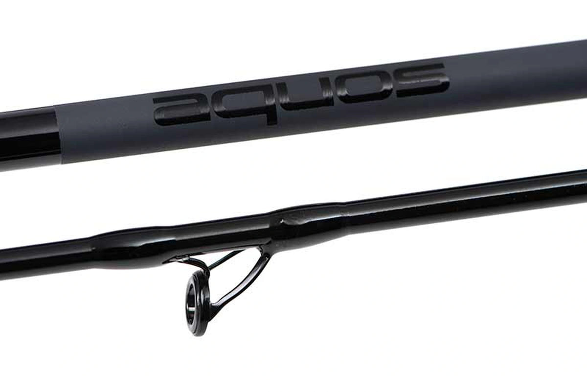 Matrix Aquos Ultra-C Feeder Rod – close-up van het zwarte Aquos-logo op de matte blank en een geleideoog op het tweede hengeldeel
