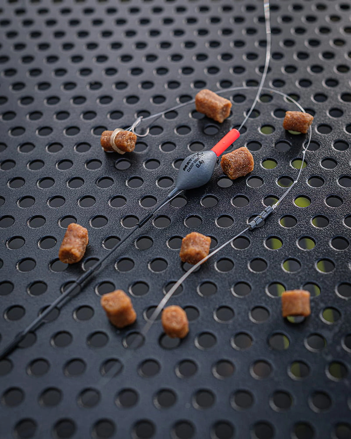 Matrix Carp Shallow Carbon Pole Float – dobber met lijnmontage, haak en pellets op een geperforeerde aastafel