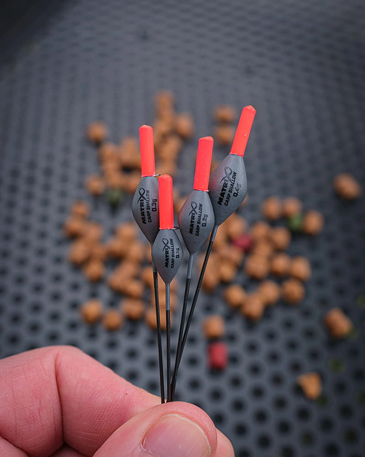 Matrix Carp Shallow Carbon Pole Floats – hand houdt de vier dobbers met de gewichten 0.10g, 0.20g, 0.30g en 0.40g