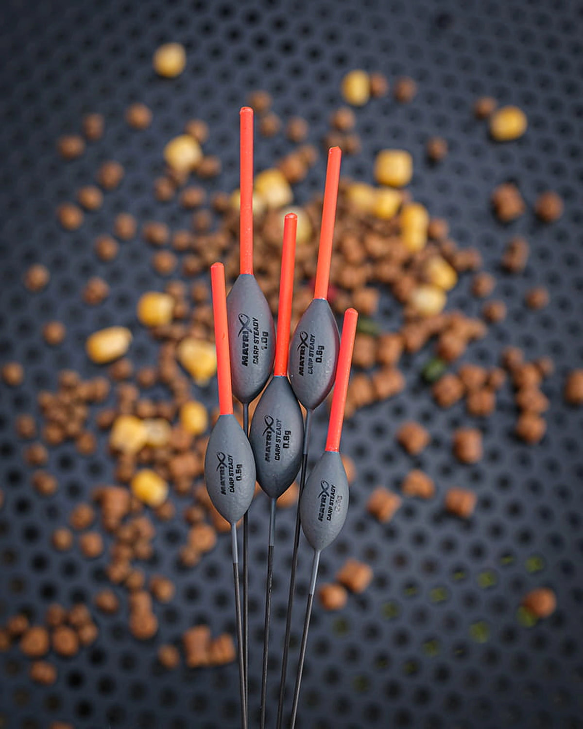 Matrix Carp Steady Pole Floats – vijf dobbers met zichtbare gewichtsopdrukken voor een achtergrond van pellets en maïs