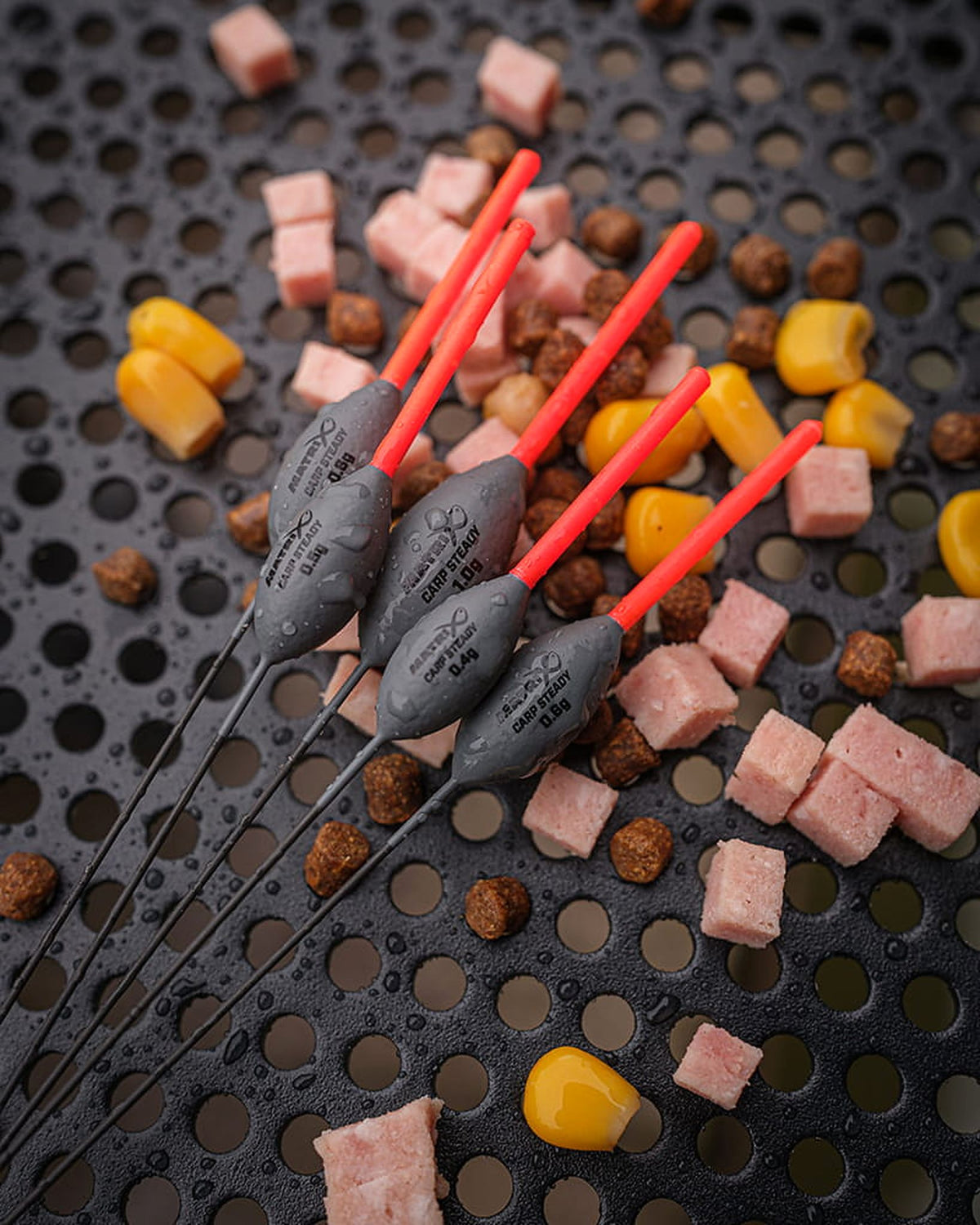 Matrix Carp Steady Pole Floats – vijf natte dobbers met waterdruppels tussen pellets, maïs en roze aasblokjes