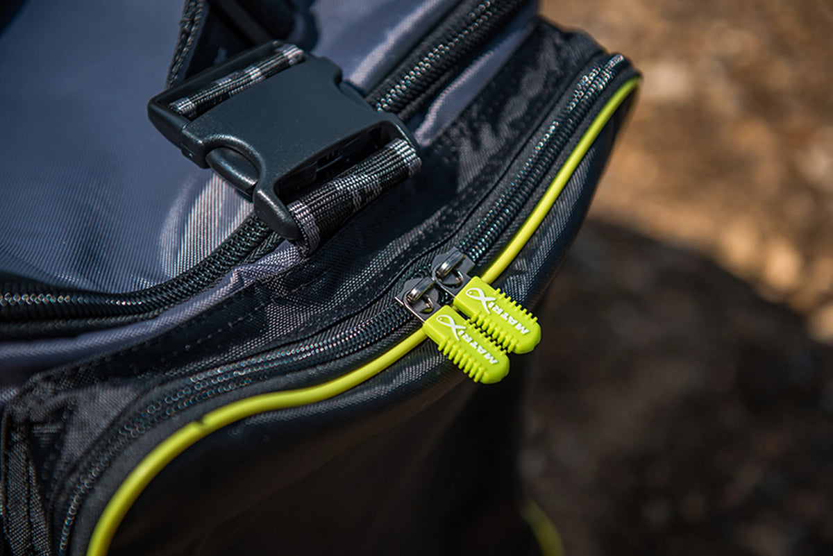 Matrix Ethos Large Carryall – buitenopname van twee gele Matrix-ritstrekkers, zwarte klikgesp en gele vakrand