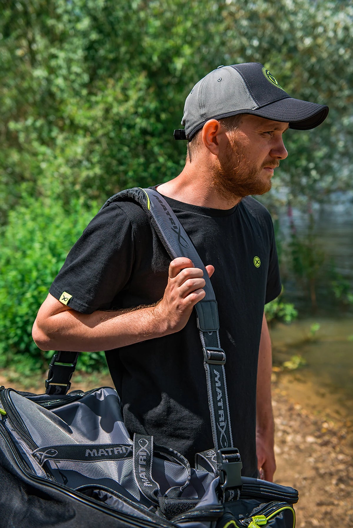 Matrix Ethos Large Carryall – detail van de gevoerde schouderriem en verstelgespen terwijl een visser de tas draagt