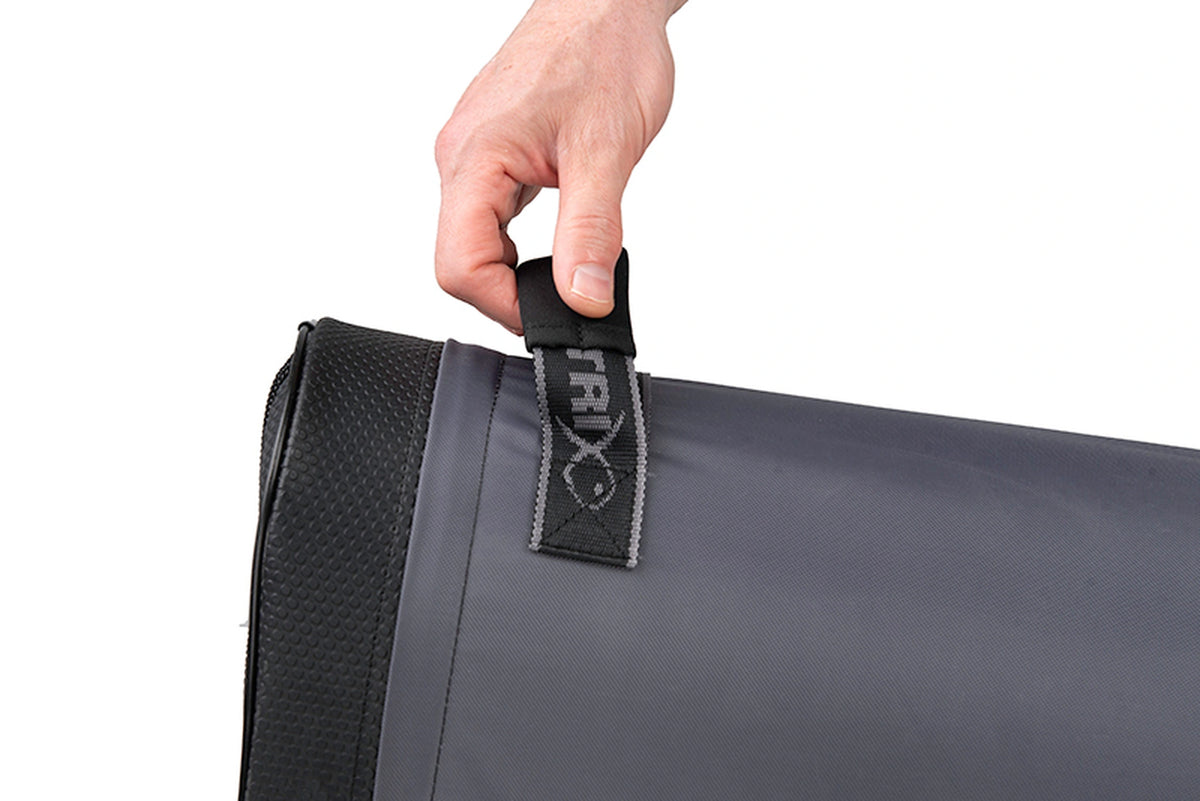 Matrix Ethos Rigid Holdall – hand aan de Matrix-handgreep bij de zwarte verstevigde bodem van het grijze foedraal