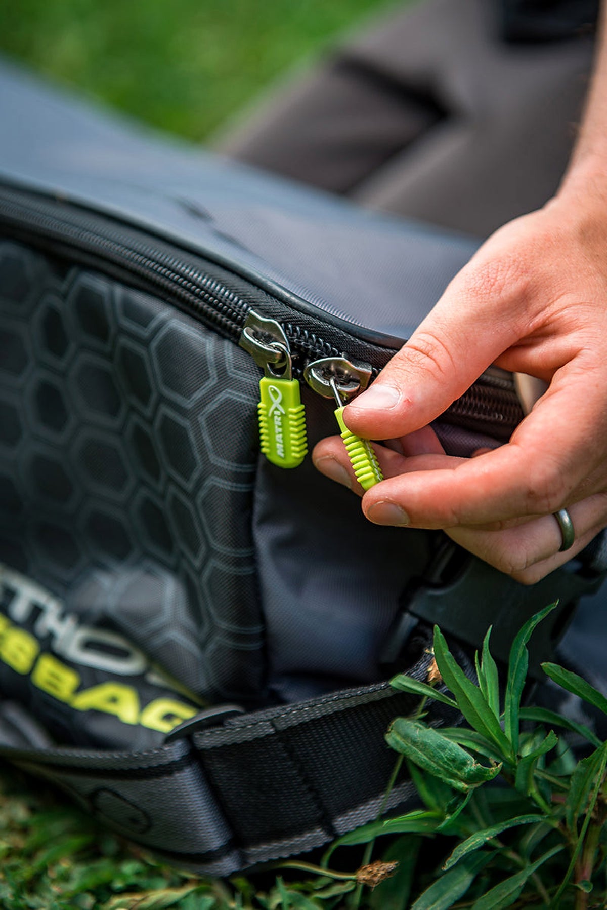 Matrix Ethos XL Accessories Bag – hand bedient de gele ritstrekker van de dubbele sluiting, verticaal detail