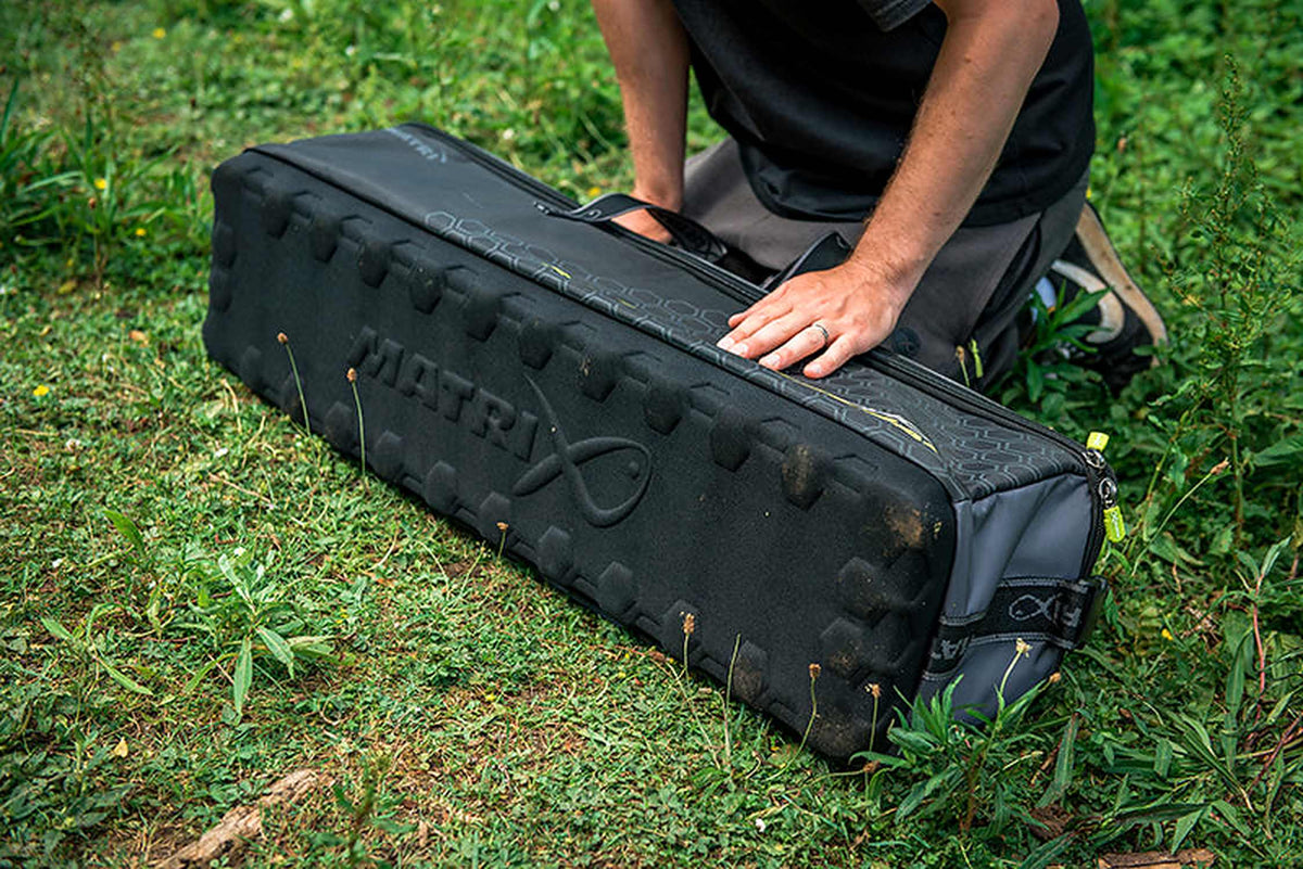 Matrix Ethos XL Accessories Bag – verstevigde zwarte bodem met Matrix-reliëflogo, getoond op het gras