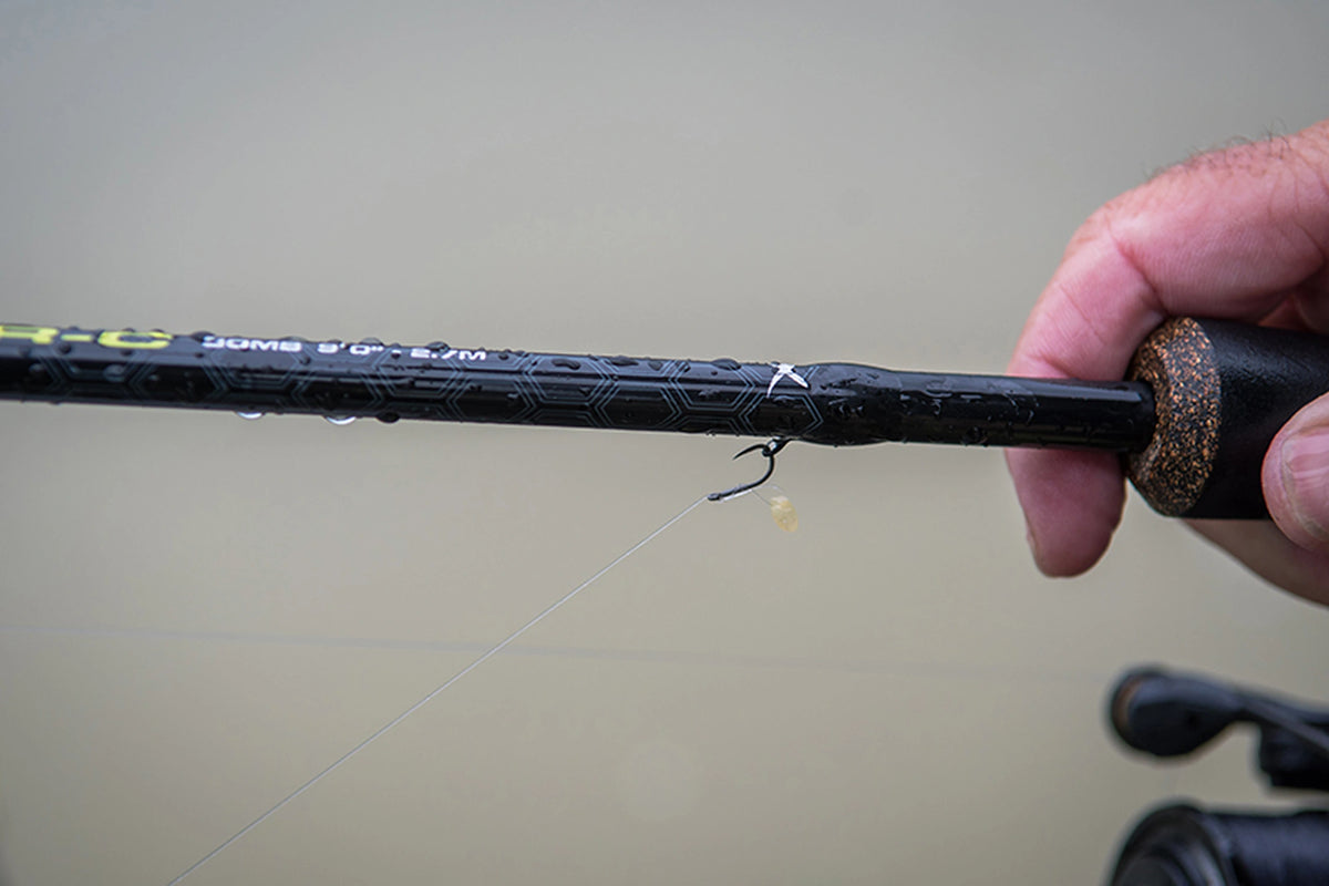 Matrix Ethos XR-C Bomb Rod 9ft – detail van de natte blank met een haak aan het haakoog en een hand om de greep