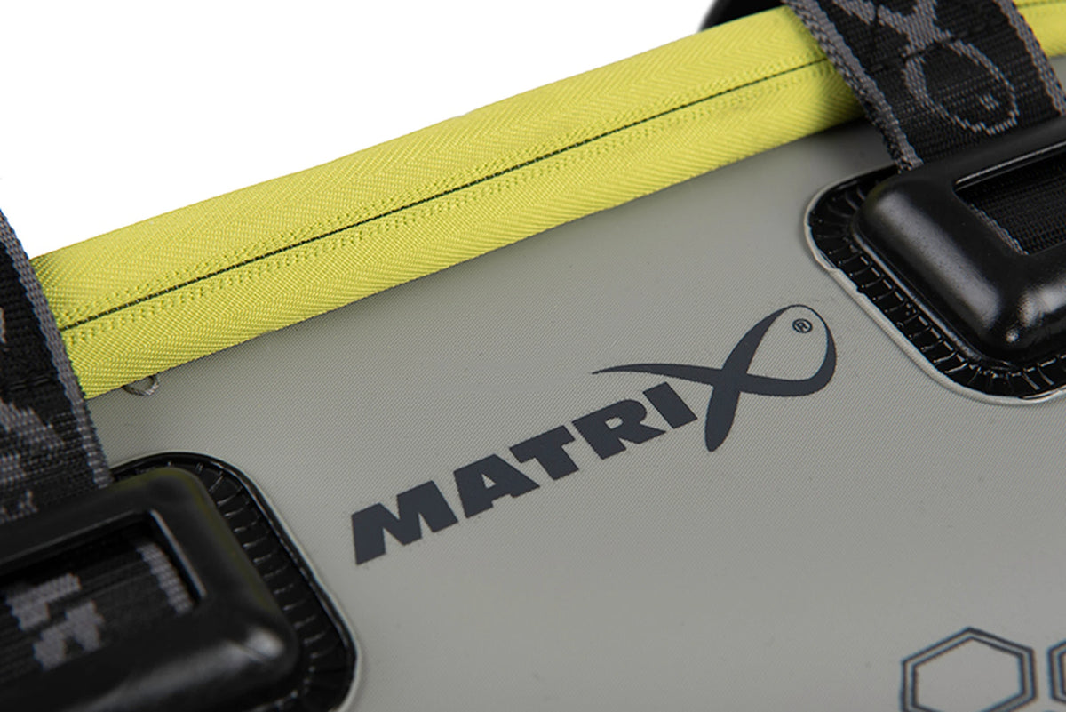 Matrix EVA Bait Storage System – detail van het Matrix-logo op de grijze voorkant, onder de gele rits