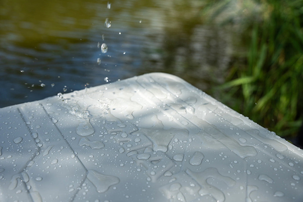 Matrix EVA Bait Storage System – water valt op het grijze deksel van de aastas aan de waterkant