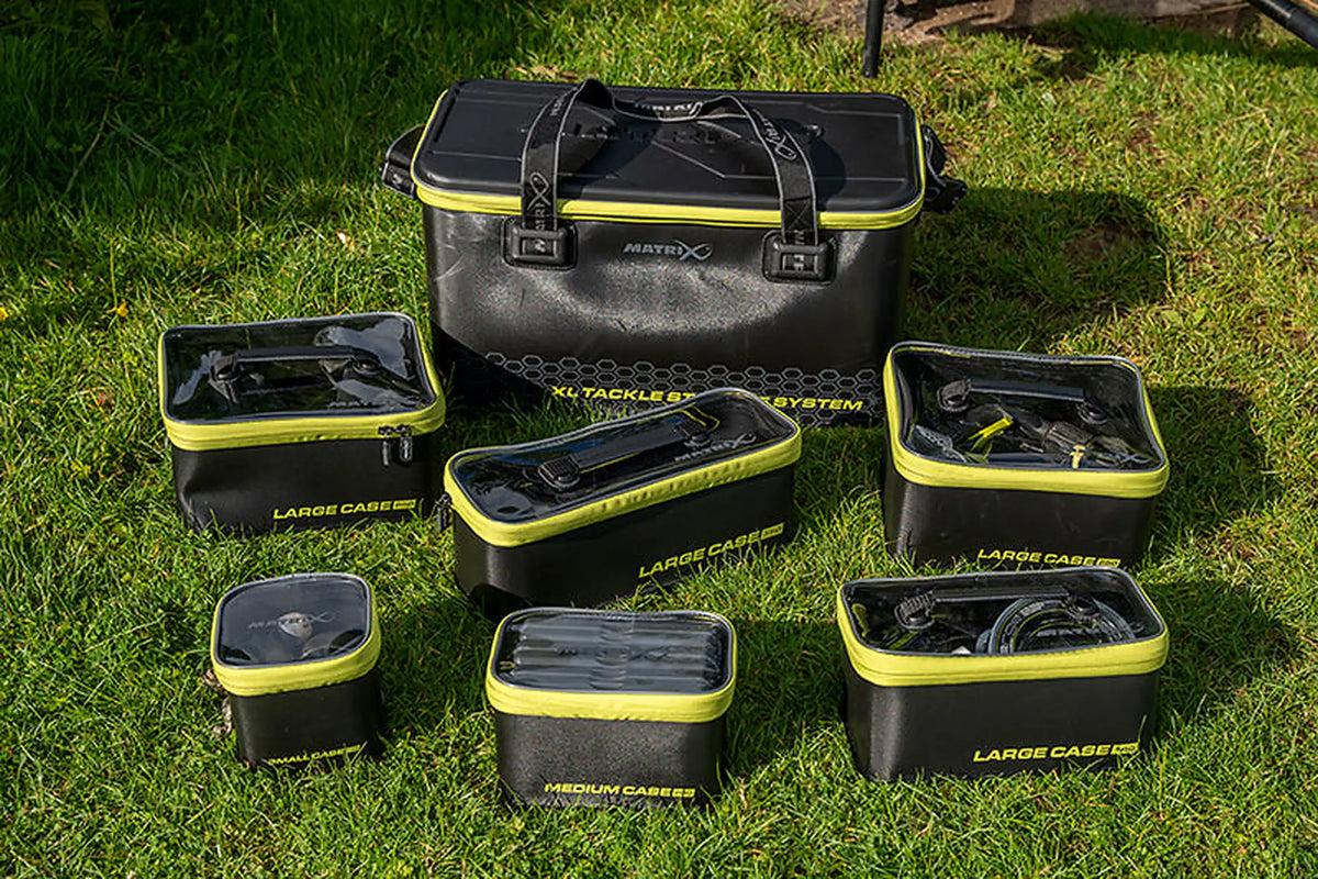Matrix EVA-opbergsysteem – Small Case 140 links vooraan bij de andere cases en grotere draagtas op het gras