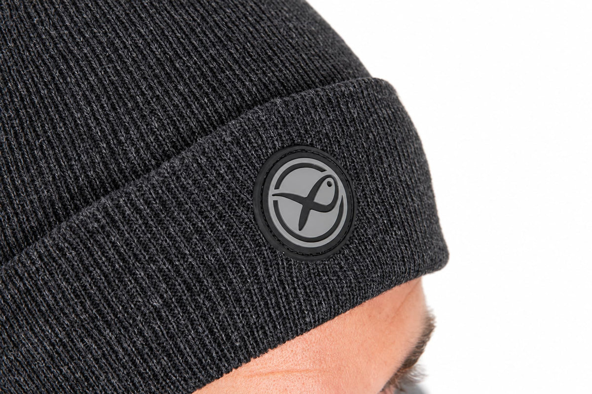 Matrix Grey Beanie detail van ronde rubberen Matrix-badge en grijze breistructuur