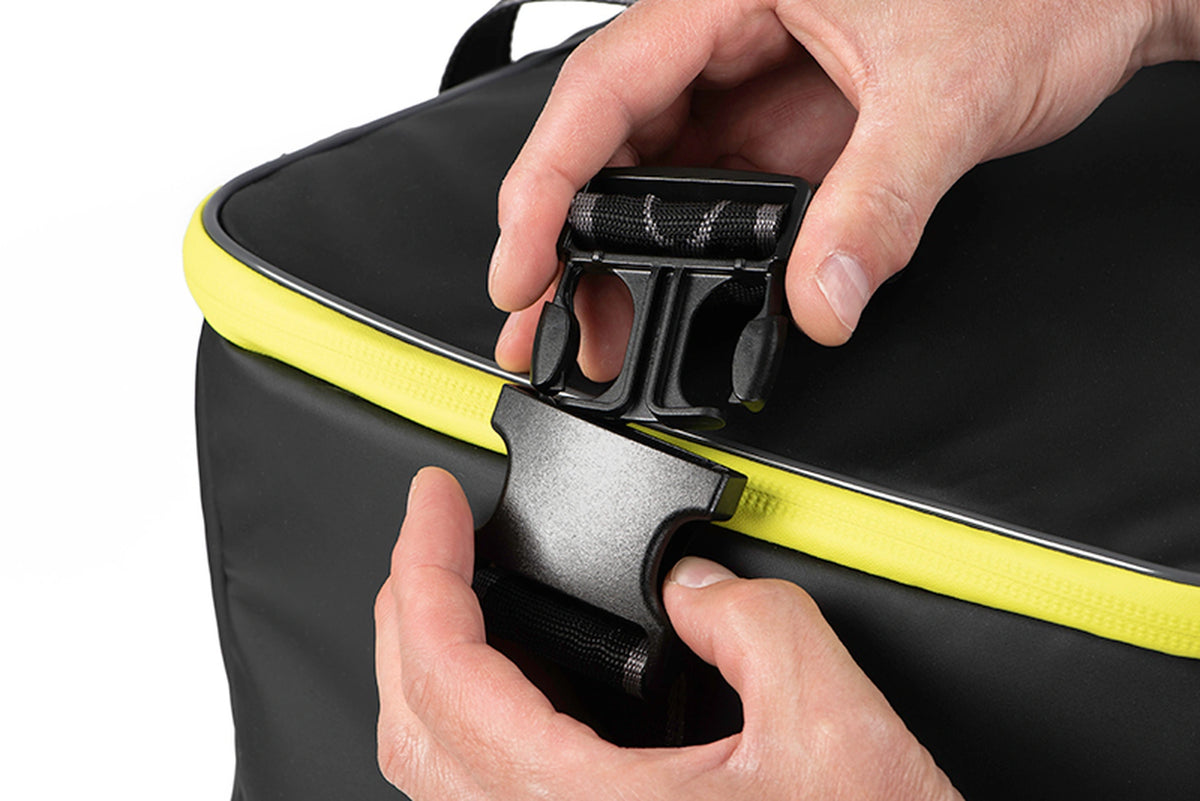 Matrix Horizon X Compact Carryall – twee delen van de geopende draagriemgesp vastgehouden boven de tas