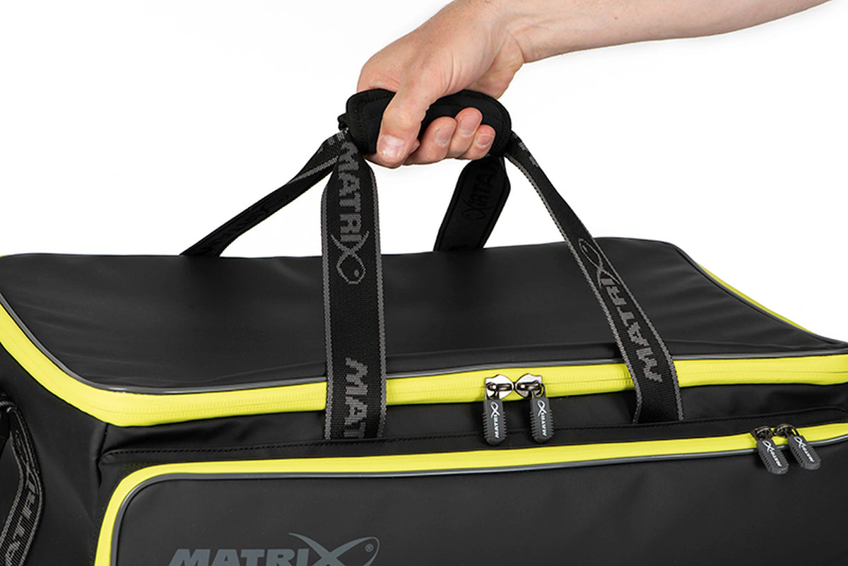 Matrix Horizon X Compact Carryall – hand rond de gevoerde handgreep met de draagriemen omhoog