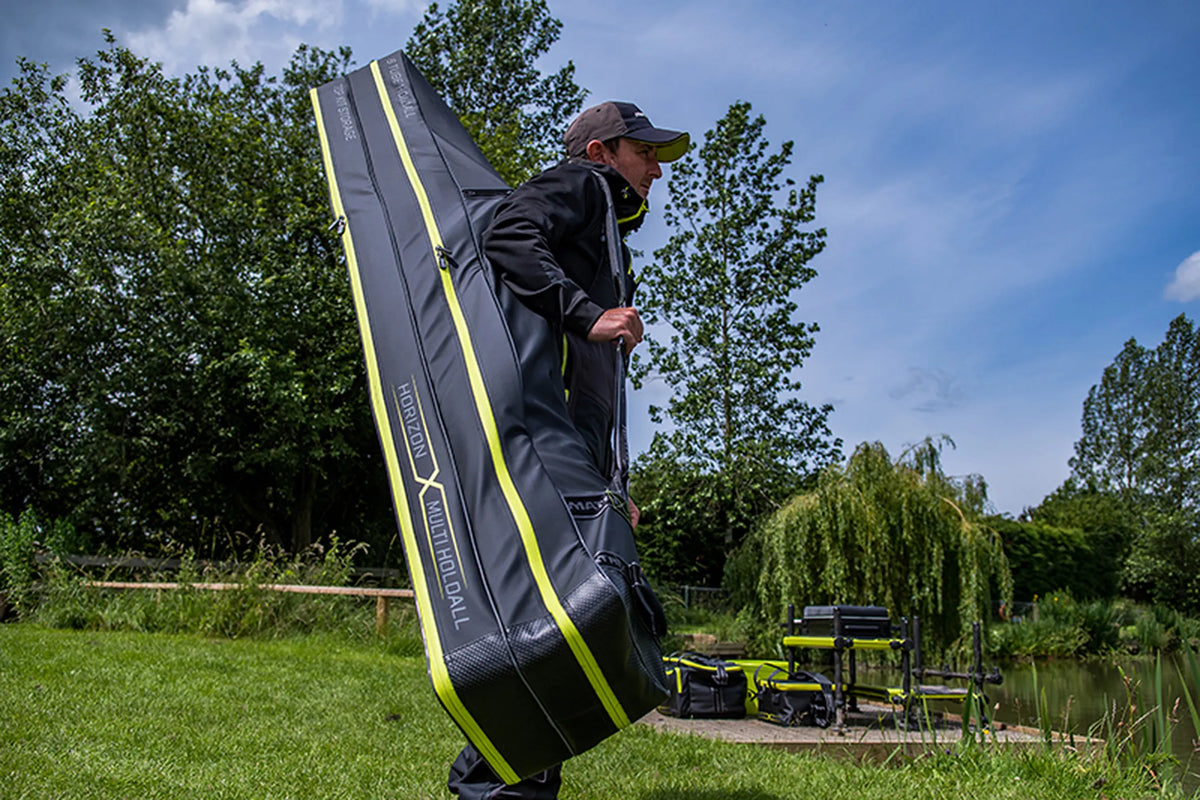 Matrix Horizon X Multi Pole Holdall – visser draagt het lange foedraal over zijn schouder langs de waterkant