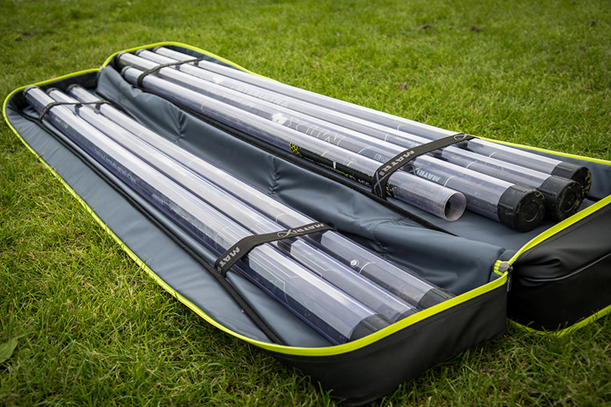 Matrix Horizon X Multi Pole Holdall – geopend foedraal in het gras met hengelkokers in beide vakken en bevestigingsriemen
