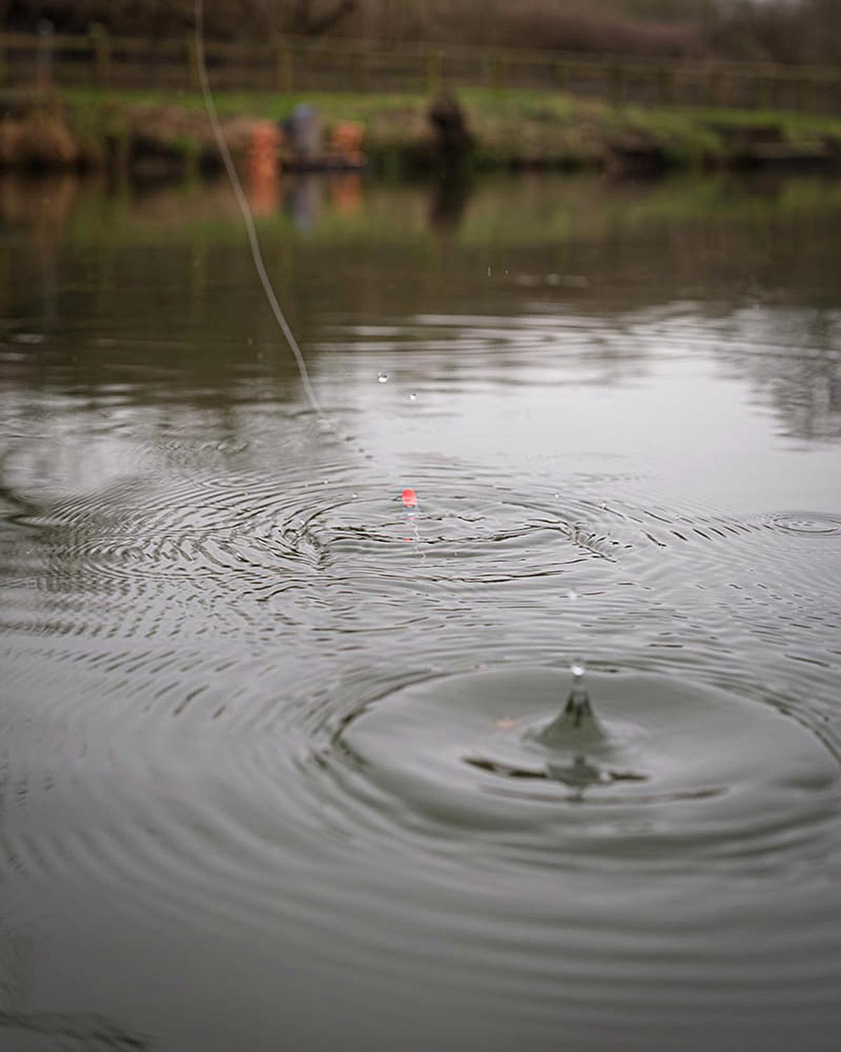 Matrix Plopper Pole Float – oranje antenne tussen waterkringen met vislijn en opspattend water