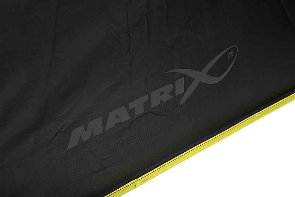 Matrix Pro Over Brolly 45 Inch – detail van het grijze Matrix-logo op het zwarte doek met gele afgewerkte rand