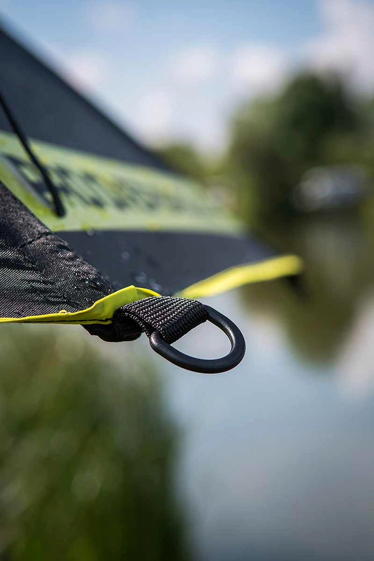 Matrix Pro Over Brolly 45 Inch – buitenopname van de zwarte bevestigingsring aan de gele doekrand met de waterkant op de achtergrond