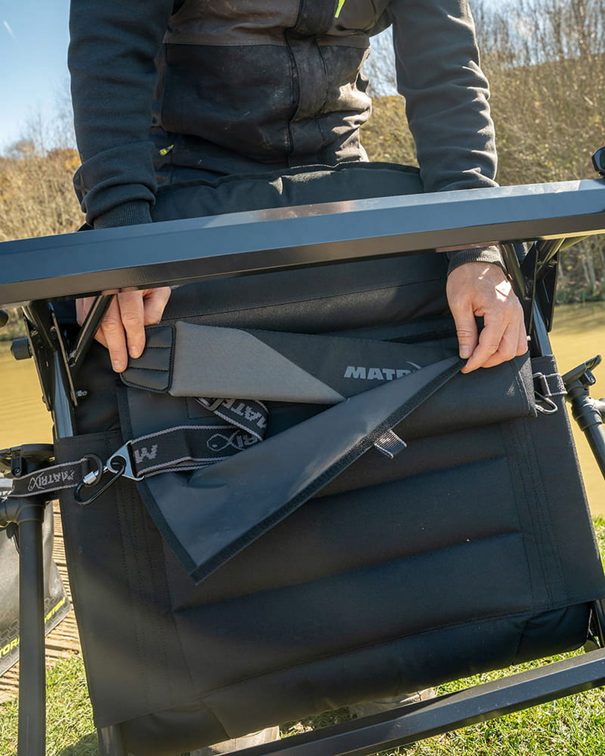 Schouderriem opbergen in het vak onder de zitting van de Matrix S25 Pro Accessory Chair