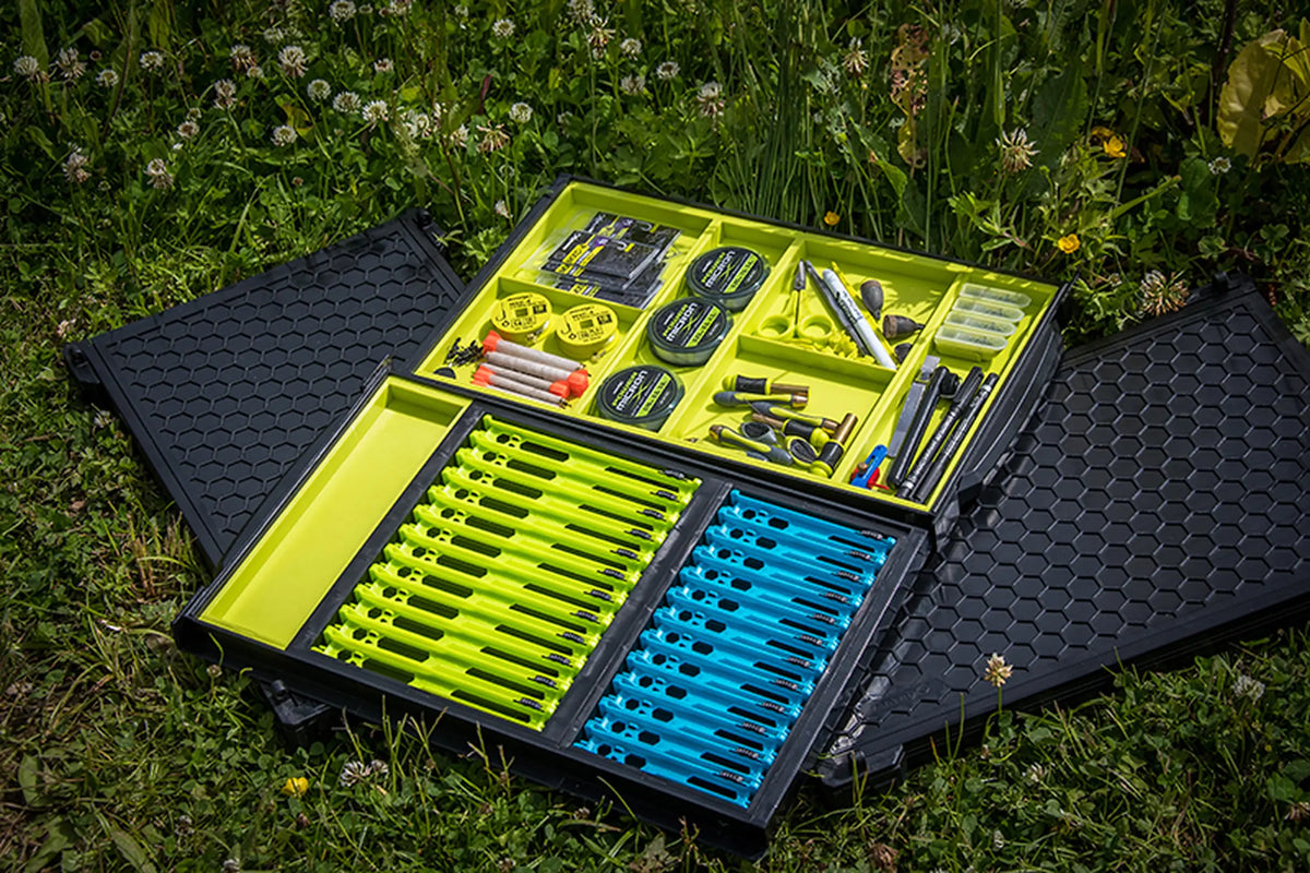 Matrix Shallow Drawer Unit with Winders – lade met tuigenplankjes op gras, naast een aparte lade met visaccessoires en losse deksels