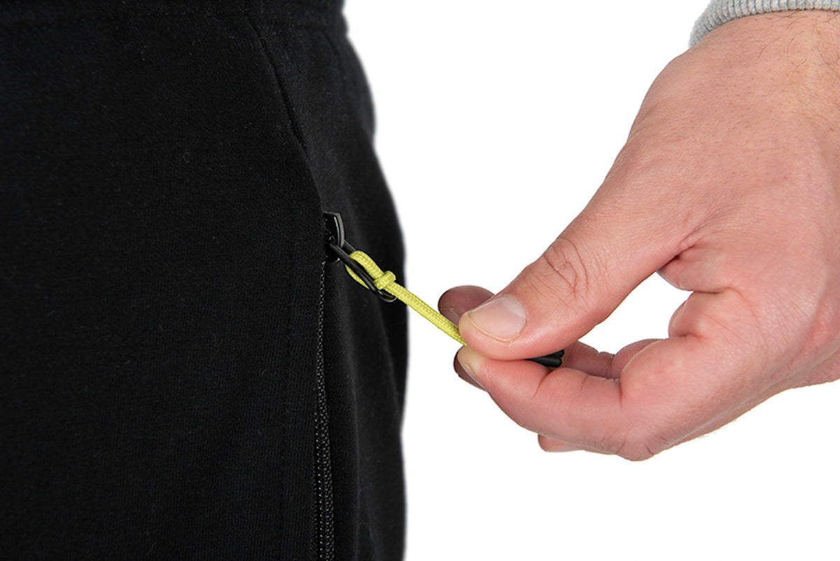 Matrix Sherpa Joggers – hand bedient de zwarte zakrits met limegroen trekkoord op de zwarte joggingbroek
