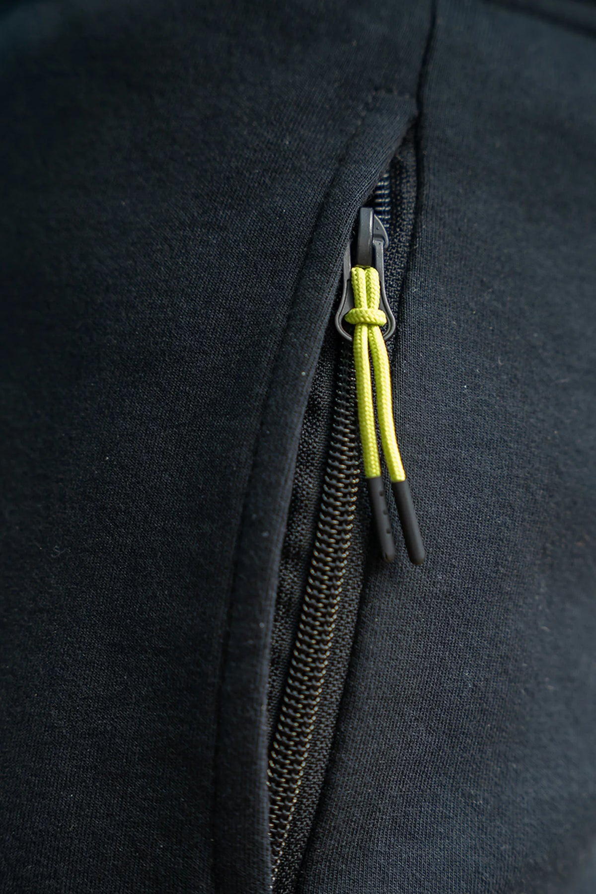 Matrix Sherpa Joggers – close-up van de zwarte zakrits met limegroene ritstrekker en zwarte uiteinden