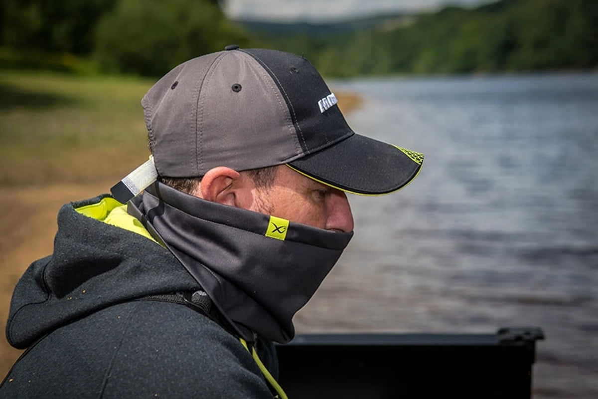 Matrix Wind Blocker Neck Warmer in zijaanzicht bij een visser aan het water