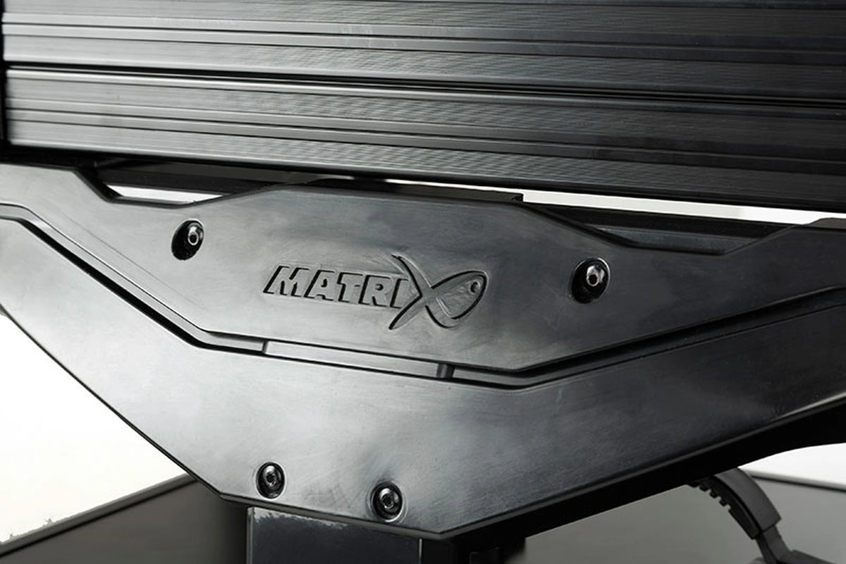 Matrix XR36 Pro Shadow Seatbox – detail van de donkere frameplaat met verzonken Matrix-logo onder de opbergmodules