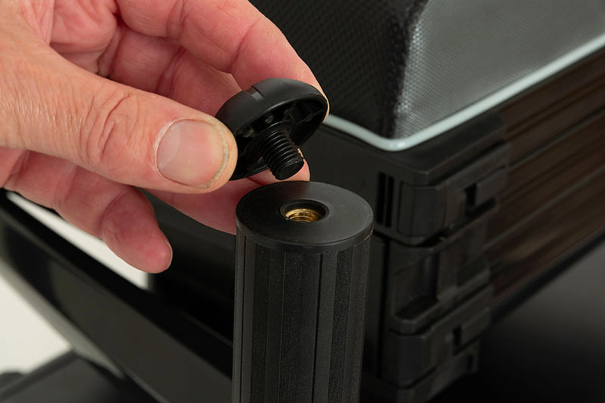 Matrix XR36 Pro Shadow Seatbox – hand toont de verwijderde zwarte pootdop en de schroefaansluiting bovenaan de poot