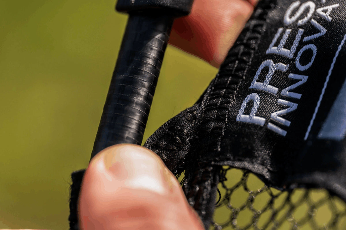 Macrodetail van het carbon frame, de gestikte netrand en een deel van het Preston Innovations-etiket van het Carbon Free Flow Landing Net