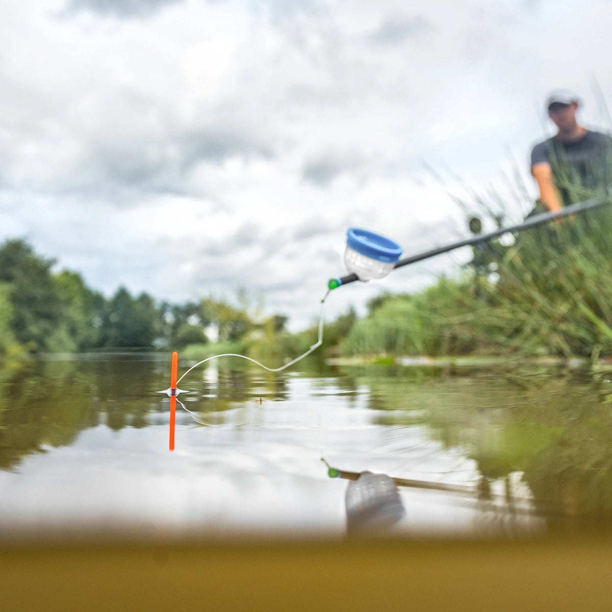 Preston Chianti dobber met oranje antenne in het water tijdens het vissen met de vaste hengel