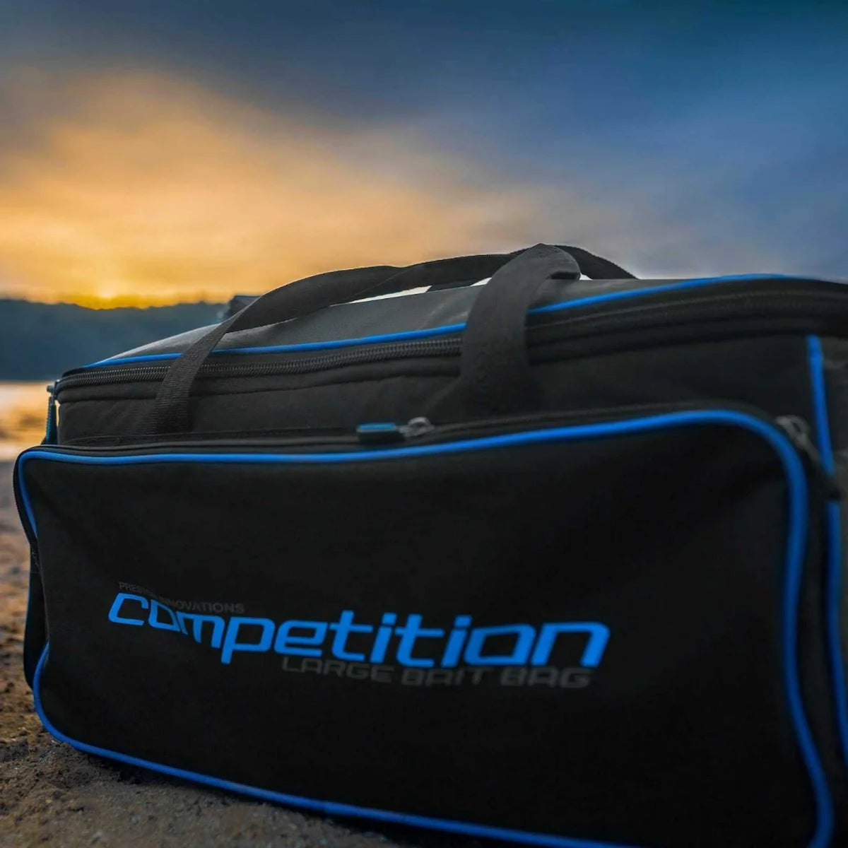 Preston Competition Large Bait Bag – zwarte aastas met blauwe randen aan de waterkant