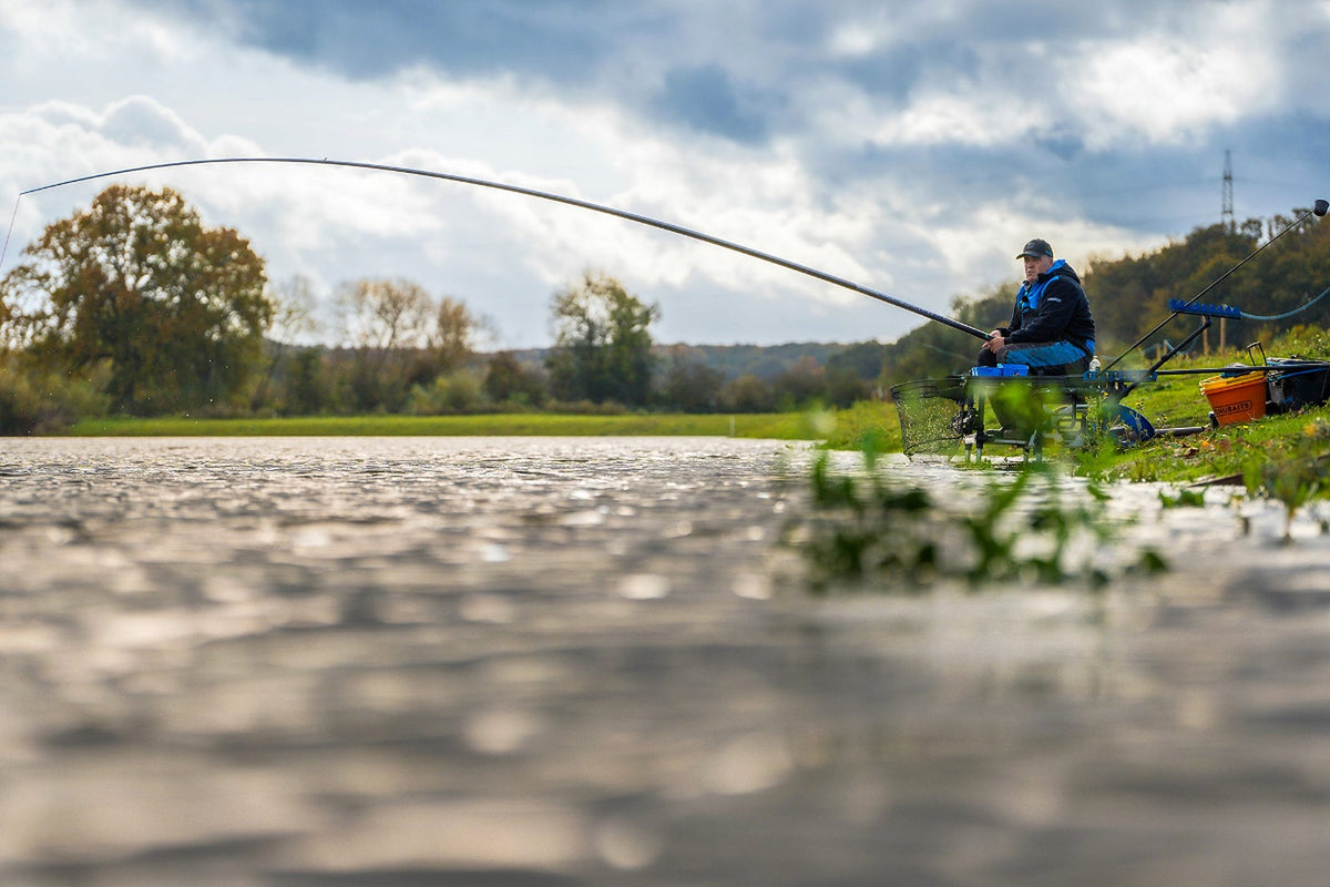 Preston Edge Monster Margin 9.5m – visser aan de waterkant met de kanthengel gebogen tijdens de dril