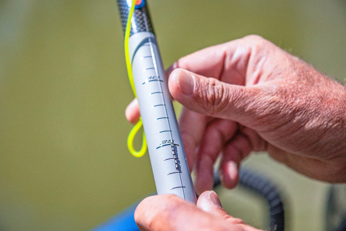 Visser controleert de dieptemarkeringen op een grijze Preston Euro Carp-topkit